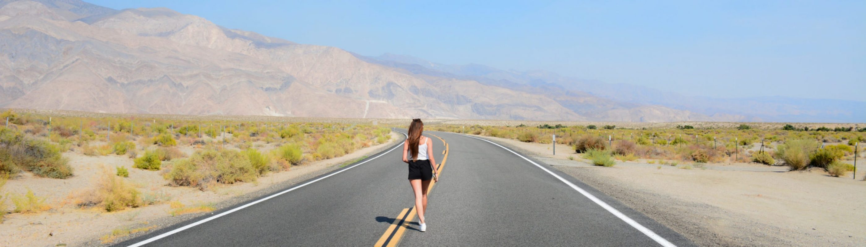 Fille qui marche sur la route de la cote ouest des Etats-Unis